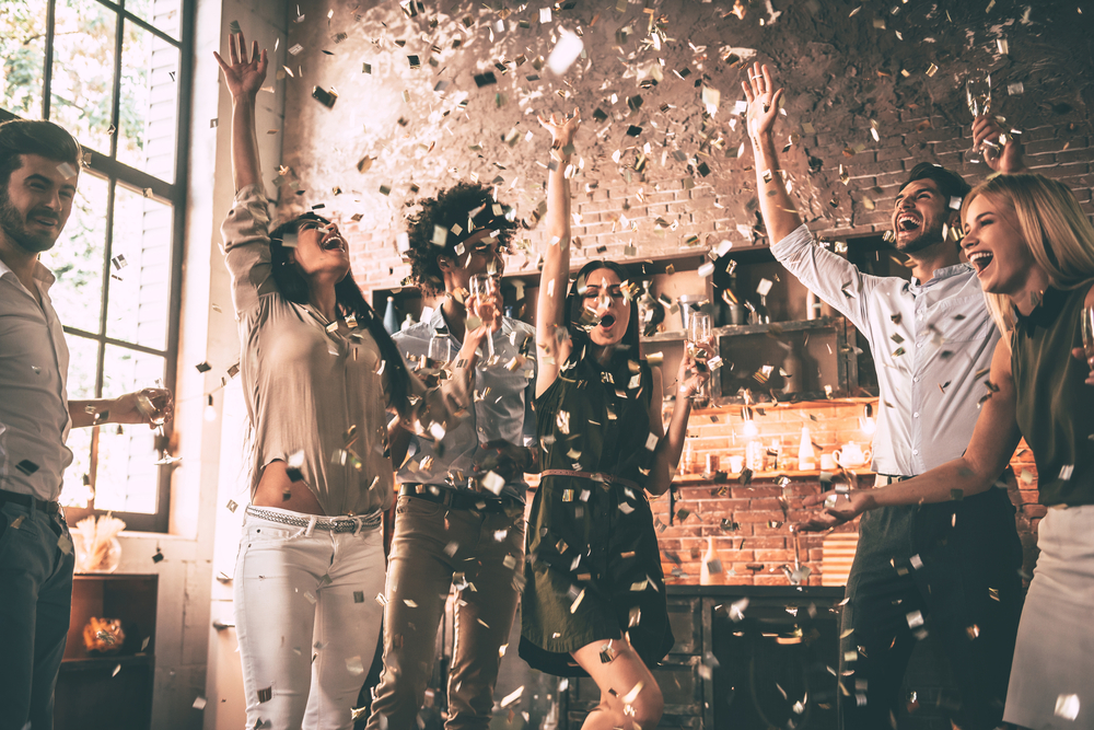 group of people celebrating with wine and confetti
